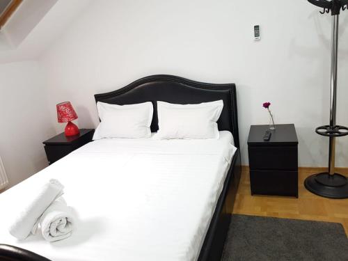 1 dormitorio con 1 cama con sábanas blancas y lámpara en Studio Buget Arena Nationala Mega Mall Monza, en Bucarest