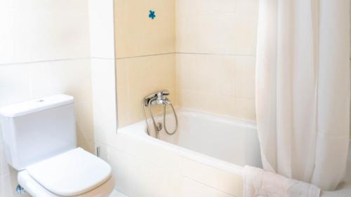 een badkamer met een toilet en een bad met een douchegordijn bij Viborilla Apartment Malaga in Málaga