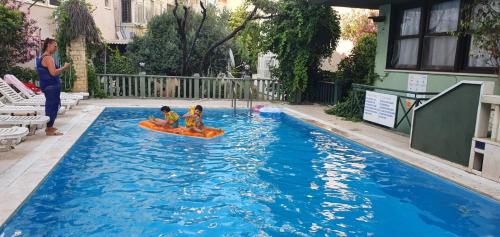 twee kinderen op een vlot in een zwembad bij Antik Apartments Marmaris in Marmaris