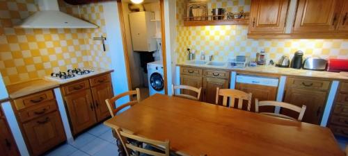 une cuisine avec une table en bois et une salle à manger dans l'établissement T4 Joseph Vernet, à Avignon