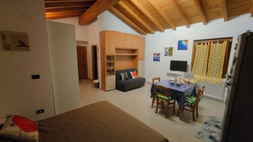 uma sala de estar com uma mesa e um sofá em casa di arya CODICE CITRA LT-0043 em Vescina