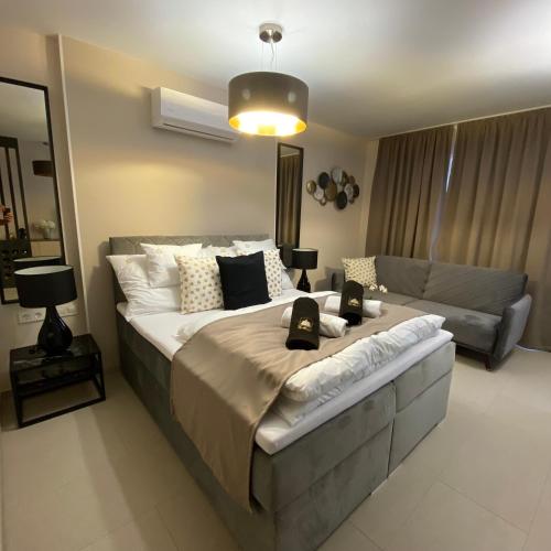 a bedroom with a large bed and a couch at CasaBlanca vendégház in Abádszalók