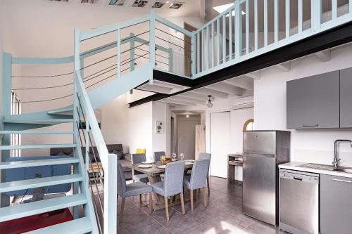 une cuisine et une salle à manger avec un escalier et une table dans l'établissement Écrin de Sable, à Vieux-Boucau-les-Bains