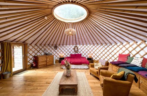 a yurt with a couch and a table in a room at La Yourte de la Ferme Froidefontaine in Havelange