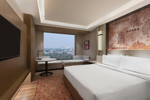 pokój hotelowy z łóżkiem i kanapą w obiekcie Courtyard by Marriott Amritsar w mieście Amritsar