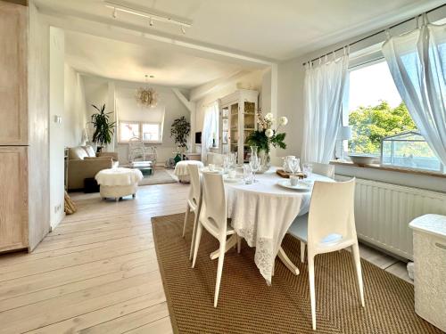 a dining room with a white table and chairs at Sopot Apartment 54 in Sopot