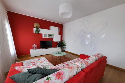 sala de estar con sofá y pared roja en Appartamento Lucia, en Vittorio Veneto