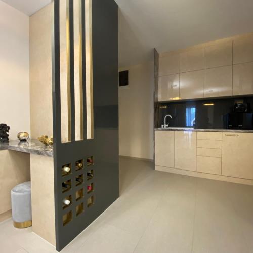 a large kitchen with white cabinets and a sink at CasaBlanca vendégház in Abádszalók