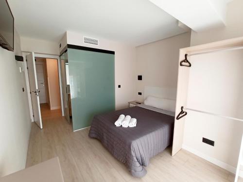 a bedroom with a bed with two white shoes on it at Bahia Rooms Cantabria 3000 in Santander
