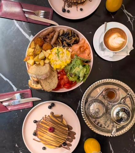 a table with plates of food and a cup of coffee at RAWAN RESIDENCY in Oujda