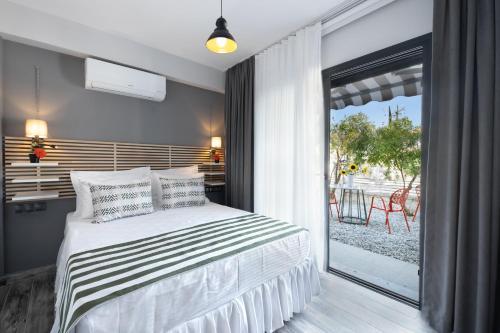 a bedroom with a bed and a large window at Villa Lui Hotel Alaçatı in Ilıca
