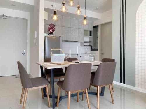 a dining room table and chairs in a kitchen at To Come Again Abode, IOI Resort City, Putrajaya in Seri Kembangan