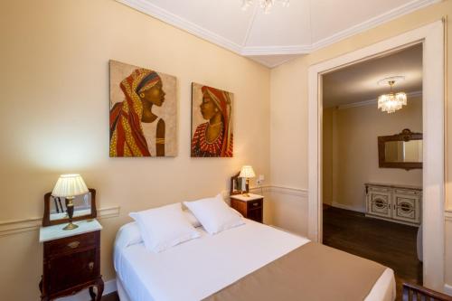 ein Schlafzimmer mit einem Bett und zwei Gemälden an der Wand in der Unterkunft Casa Jurado in El Paso