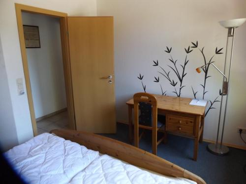 a bedroom with a bed and a desk and a desk at Ferienwohnung Hahnenkrug in Selk