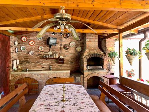 Habitación grande de piedra con mesa y ventilador de techo. en Casa Ramona en Turda