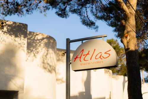 Un cartello di Aania su un palo di fronte a un edificio di Atlas Apartments Ibiza a Santa Eularia des Riu