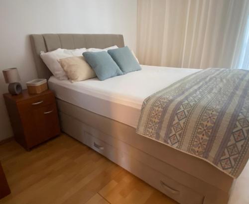 ein Bett mit zwei Kissen darauf in einem Schlafzimmer in der Unterkunft Apartmani Perić in Stari Grad