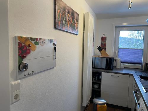 a kitchen with a refrigerator freezer next to a window at Harzstübl25 in Sankt Andreasberg