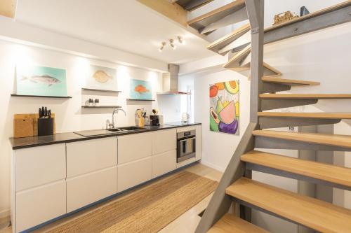 a kitchen with white cabinets and a staircase at Cascais Petit Bijou by CadenzaLux in Cascais
