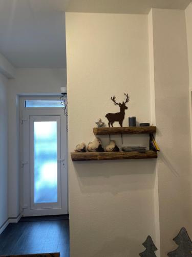 a shelf with a deer on a wall next to a door at Harzstübl25 in Sankt Andreasberg