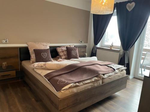a bedroom with a large bed with blue curtains at Harzstübl25 in Sankt Andreasberg