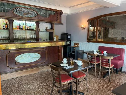 un restaurante con mesas y sillas y un bar en Hôtel Les trois maures, en Verdun-sur-le-Doubs