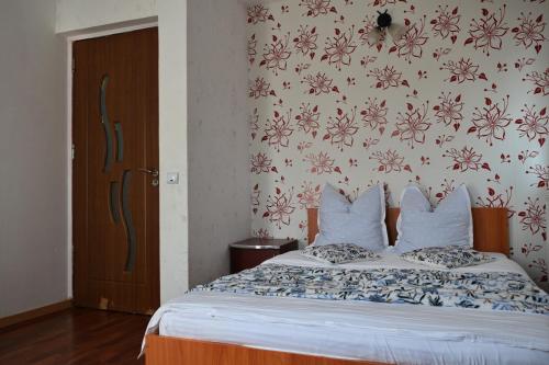 a bedroom with a bed with a floral wallpaper at Cabana Denis&Lucas in Ocna Şugatag