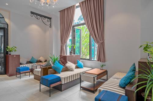 a living room with couches and blue pillows at Rex Quang Binh Hotel in Dong Hoi