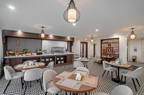 a restaurant with tables and chairs and a kitchen at Rex Quang Binh Hotel in Dong Hoi