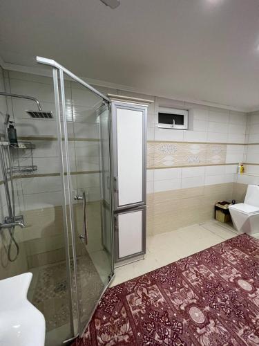 a shower with a glass door in a bathroom at Naryn Cozy House in Naryn
