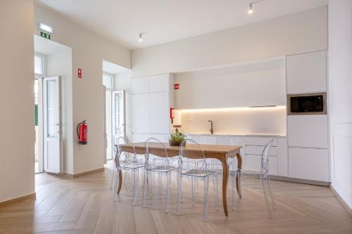 uma cozinha com mesa e cadeiras num quarto em Guest House Jacarandá Faro em Faro