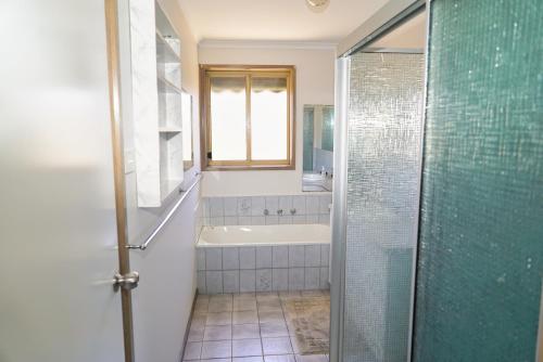 a bathroom with a shower and a tub and a sink at COZY 2 BEDROOM HOUSE /MELBOURNE in Werribee