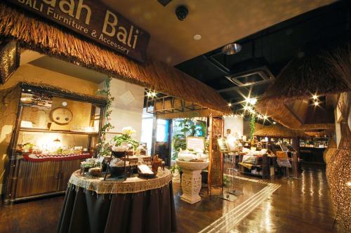 a restaurant with tables and a bar in a building at BaliAn Resort Chiba-Chuo in Chiba