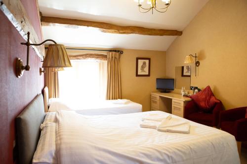 a hotel room with a bed and a window at Coach House in High Bentham