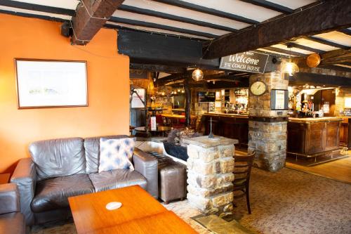 a living room with a leather couch and a bar at Coach House in High Bentham