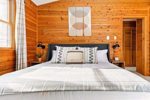 a bedroom with a bed in a wooden wall at Luxe Lake Harmony Home, Game Room, Firepit, Deck in Spilt Rock