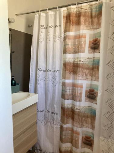 La salle de bains est pourvue d'un rideau de douche avec les mots « genderol ». dans l'établissement Villa Rose Suite et chambres, à Montpellier