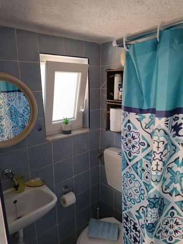 a bathroom with a toilet and a sink and a window at Olive metohi return to nature in Azokéramos
