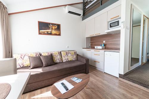 a living room with a couch and a kitchen at Atrijum Apartments and Rooms in Kladovo
