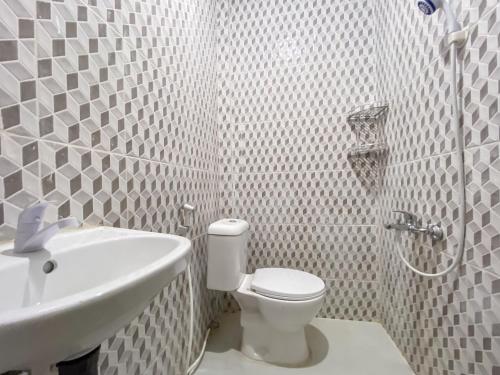 Sagulung的住宿－RedDoorz @ Cikitsu Batam，白色的浴室设有卫生间和水槽。