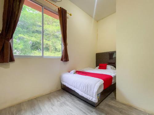 1 dormitorio con cama y ventana en RedDoorz @ Cikitsu Batam en Sagulung