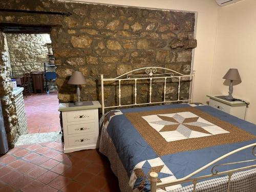 1 dormitorio con cama y pared de piedra en Case Vacanza Villa Bentivoglio en Piazza Armerina
