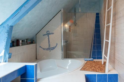 een badkamer met een bad met een anker aan de muur bij Les Granges De Kergroes in Guidel