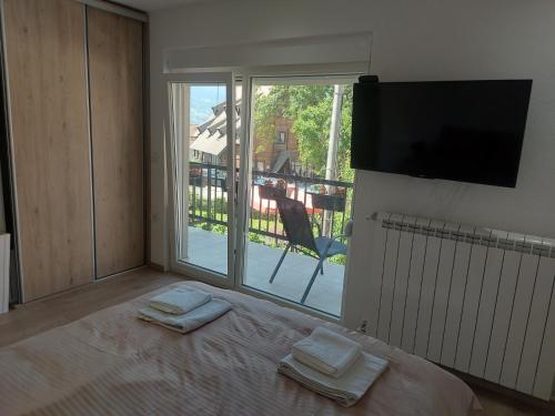a bedroom with a bed with two towels on it at Rooms Lida & Friendly home in Plav