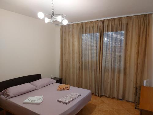 ein Schlafzimmer mit einem Bett und einem großen Fenster in der Unterkunft Mano' s Place in Tirana