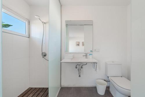 a white bathroom with a sink and a toilet at Es Forti 52 in Santanyi