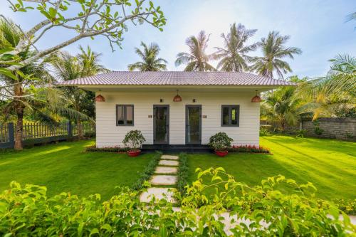 a white house with a green yard at Emerald Garden Retreat in Phu Quoc
