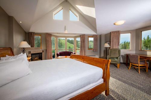sypialnia z dużym łóżkiem i kominkiem w obiekcie Winter Park Mountain Lodge w mieście Winter Park