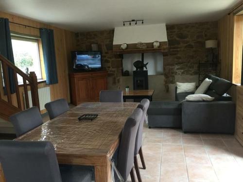 un salon avec une table et un canapé dans l'établissement Longère Bretonne près du GR34, à Trébeurden