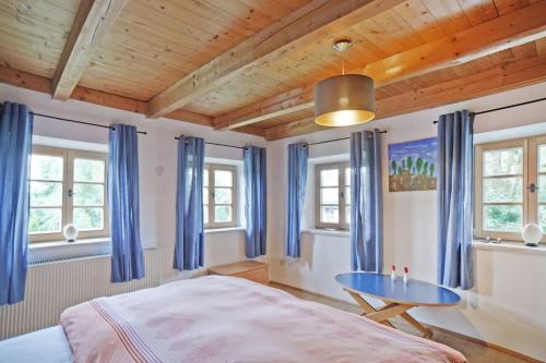 ein Schlafzimmer mit einem Bett und einem blauen Tisch in der Unterkunft Der Birkenhof-Ried in Pfaffing